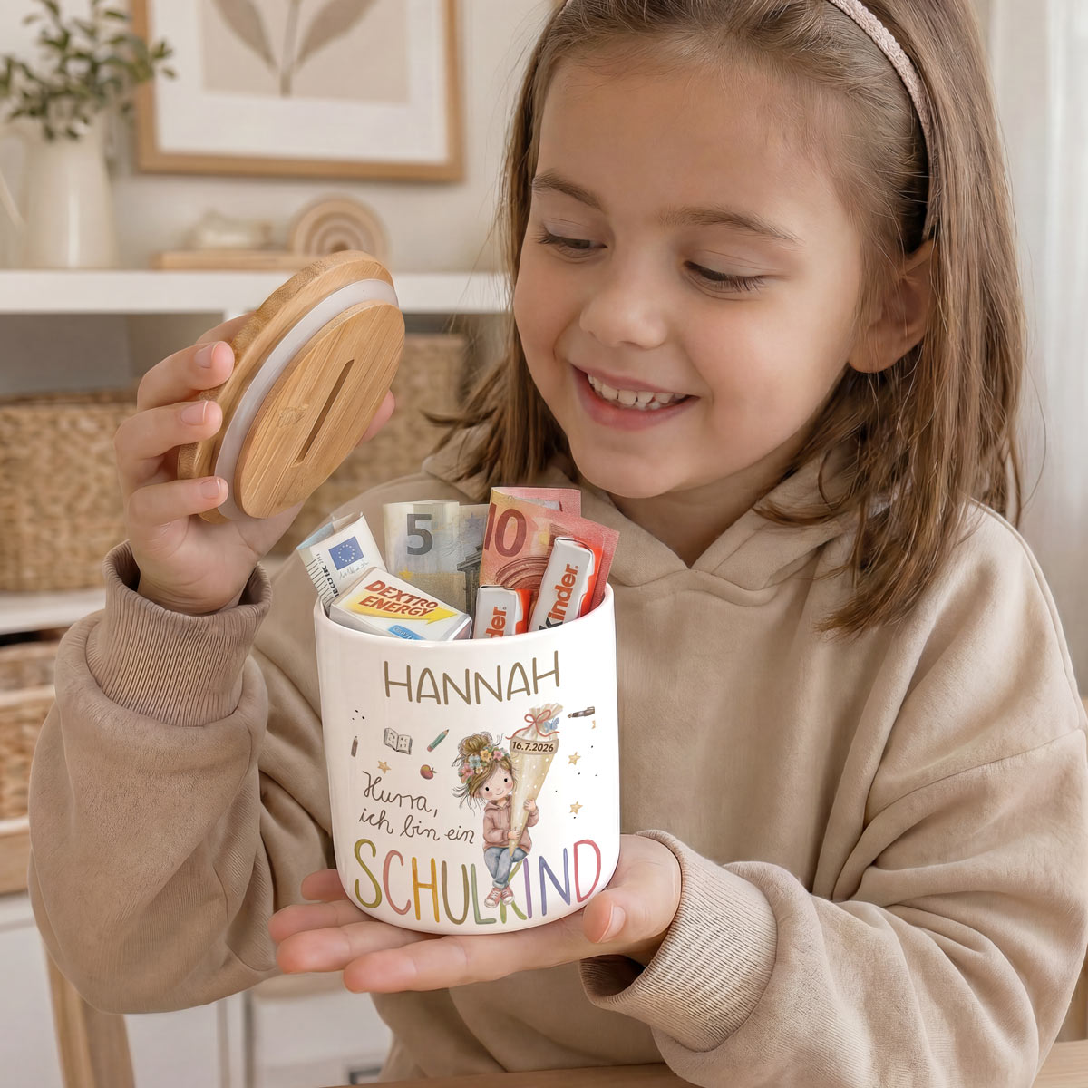 Nahaufnahme des brillanten und personalisierten Aquarell-Drucks auf der weißen Keramikdose, der ein fröhliches Schulkind mit Wunschnamen und Datum zeigt.