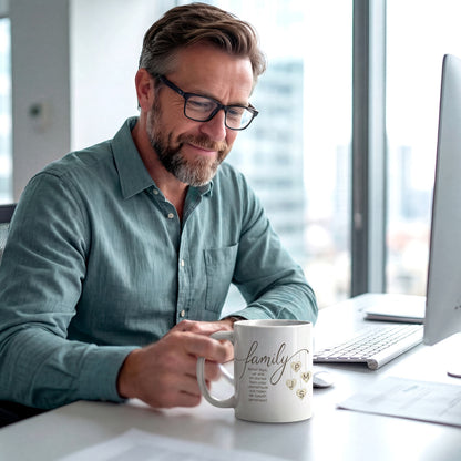 Ein Vater sitzt im Büro und schaut lächelnd auf seine personalisierte Kaffeetasse mit Familien-Initialen. Modernes Lifestyle-Design im modernen Stil.