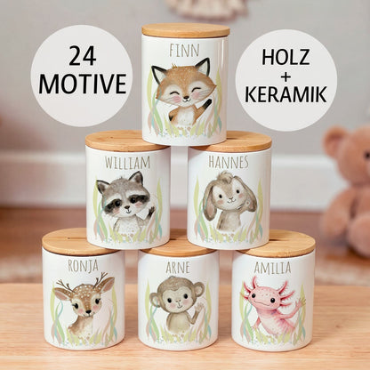 Personalisierte Spardosen aus weißer Keramik mit Bambusdeckel, bedruckt mit dem Namen des Kindes und winkenden Tieren zur Auswahl als Aquarell-Motiv.