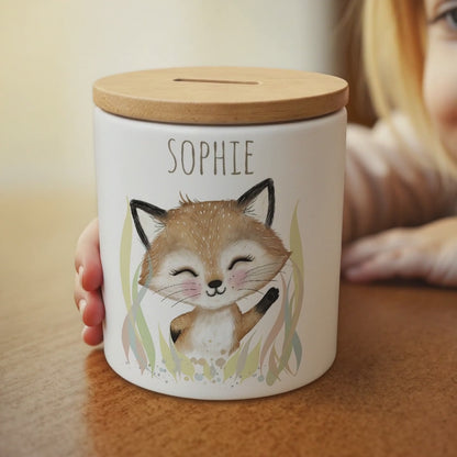 Ein kleines Mädchen winkt verträumt dem Fuchs-Motiv auf der Spardose zu