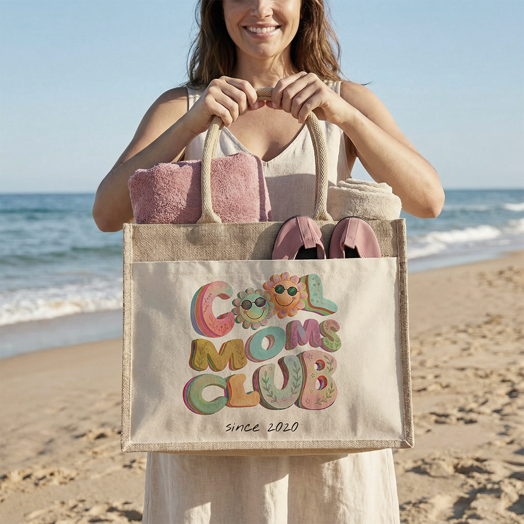 Eine stolze Mutter am Strand trägt die große XXL Boho Strandtasche aus Jute über der Schulter.