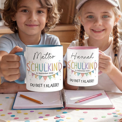 Personalisierte Keramiktasse zur Einschulung in den Farben Rosa, Blau und Weiß, bedruckt mit dem Wort Schulkind, einer Aquarell-Wimpelkette und dem Namen des Kindes.