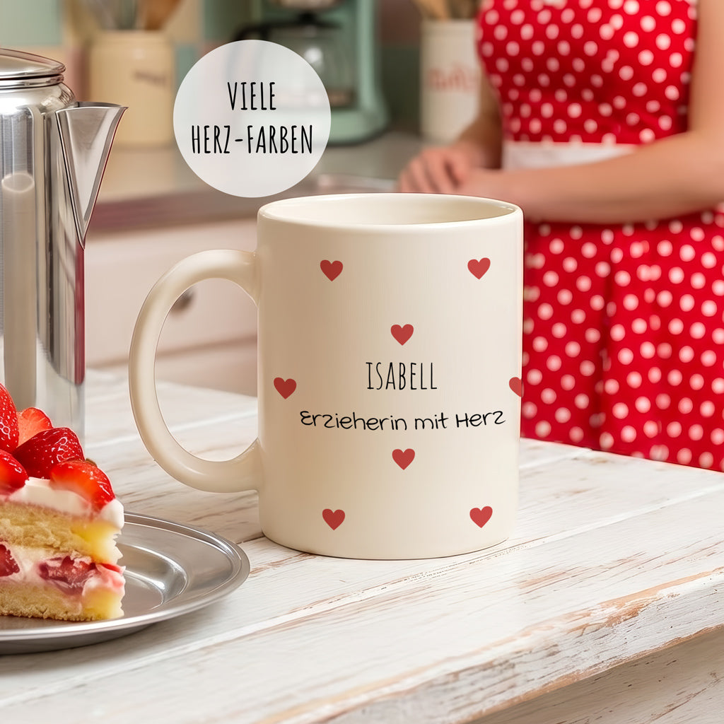 Personalisierte Dankeschön-Tasse für Erzieherinnen mit rosa Herzchen-Muster und dem Namen des Kindes, dekoriert auf einem modernen Holztisch.